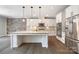 Bright kitchen featuring a large island, stone accent wall, stainless steel appliances, and modern cabinetry at 300 Hidden Cove Ln, Matthews, NC 28104