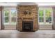 Living room with stone fireplace, large windows and decorative curtains at 300 Hidden Cove Ln, Matthews, NC 28104