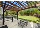 An outdoor patio area featuring a pergola, outdoor seating and a beautiful green lawn at 300 Hidden Cove Ln, Matthews, NC 28104