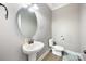 Powder room featuring pedestal sink, oval mirror, and tile flooring at 300 Hidden Cove Ln, Matthews, NC 28104