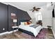 Stylish bedroom featuring dark accent walls, a comfortable bed, a large window, and modern lighting fixtures at 300 W 5Th St # 644, Charlotte, NC 28202