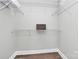 Walk-in closet features white shelves, wood floors, and natural lighting at 300 W 5Th St # 644, Charlotte, NC 28202