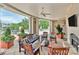 A beautifully furnished outdoor patio with fireplace, TV, pillars, ceiling fans and lush landscaping at 300 W 5Th St # 644, Charlotte, NC 28202