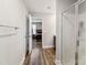 Hallway with wood floors, a bathroom with a glass-enclosed shower, and a view into the main bedroom at 3401 Shillinglaw Rd, Sharon, SC 29742