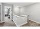 Upstairs hallway featuring neutral carpet, light gray walls, and a white banister overlooking the staircase at 3401 Shillinglaw Rd, Sharon, SC 29742