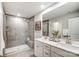 Modern bathroom with a double sink vanity, glass-enclosed shower, and neutral tile at 3922 Cheyney Park Dr, Charlotte, NC 28269