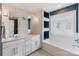 Bright bathroom with double sink vanity, mosaic tile, and a built-in tub with frosted window at 423 State St, Charlotte, NC 28208