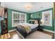 Bright bedroom with green walls, large windows, and a comfortable bed with a colorful quilt at 423 State St, Charlotte, NC 28208