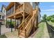 Exterior view of wooden stairs leading to a screened in wooden porch and a well maintained yard at 423 State St, Charlotte, NC 28208