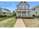 Beautiful two-story home with a welcoming front porch, complemented by a bright yellow door at 423 State St, Charlotte, NC 28208