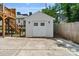 Detached, white one car garage with matching double doors, two windows, and carriage lights above at 423 State St, Charlotte, NC 28208