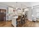 Modern kitchen featuring white cabinets, stainless steel appliances, a breakfast bar with seating, and hardwood floors at 423 State St, Charlotte, NC 28208