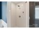 Clean and modern all-white tiled shower featuring a shower head and chrome fixtures at 423 State St, Charlotte, NC 28208