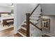 Staircase with wood steps and white banister leads to bedroom featuring wood floors at 423 State St, Charlotte, NC 28208