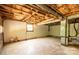 An unfinished basement with exposed ceiling beams, concrete flooring, and a small window at 462 Berry Hill Dr, Norwood, NC 28128