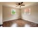 Bright bedroom featuring hardwood floors, two windows, and a ceiling fan at 462 Berry Hill Dr, Norwood, NC 28128