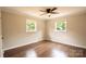 Cozy bedroom with wood flooring, two bright windows, and a ceiling fan at 462 Berry Hill Dr, Norwood, NC 28128
