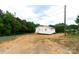 A well-maintained, light yellow home with a wood deck, situated on a partially landscaped lot near a quiet street at 462 Berry Hill Dr, Norwood, NC 28128