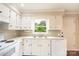 Bright kitchen with white cabinets and appliances, window, and modern sink at 462 Berry Hill Dr, Norwood, NC 28128