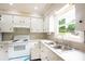 Well-maintained kitchen with a garden window and sleek, white countertops and appliances at 462 Berry Hill Dr, Norwood, NC 28128