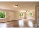 Bright living room featuring wood floors, ceiling fan, and open layout with large windows at 462 Berry Hill Dr, Norwood, NC 28128