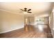 Bright living room featuring wood floors, ceiling fan, and open layout with kitchen and bathroom views at 462 Berry Hill Dr, Norwood, NC 28128