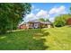 Spacious backyard featuring a screened porch and play area with mature trees at 4860 Sherborne Dr, Harrisburg, NC 28075