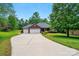 Beautiful single-story brick home with a three-car garage, long driveway, and mature landscaping at 4860 Sherborne Dr, Harrisburg, NC 28075
