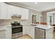 Bright kitchen featuring white cabinets, stainless steel appliances, and light wood flooring at 4860 Sherborne Dr, Harrisburg, NC 28075