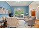 Cozy living room featuring hardwood floors, neutral decor, and a large window providing ample natural light at 4860 Sherborne Dr, Harrisburg, NC 28075