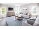 Well-lit living room with comfortable seating, modern furnishings, and ample natural light from multiple windows at 518 Durango Way, Denver, NC 28037