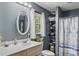 Well-lit bathroom with a single sink vanity, oval mirror, and a shower with a patterned curtain at 536 Brookhaven Rd, Statesville, NC 28625