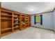 Bedroom with built-in wooden bookshelves, blue walls, and a bright window dressed in blue curtains at 536 Brookhaven Rd, Statesville, NC 28625