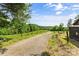 Scenic gravel driveway leading through lush greenery under a bright blue sky at 536 Brookhaven Rd, Statesville, NC 28625