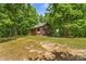 Exterior view of a cozy cabin with a covered porch surrounded by lush greenery and trees at 536 Brookhaven Rd, Statesville, NC 28625