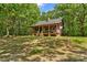 Charming cabin-style home with a covered front porch and stone chimney surrounded by mature trees at 536 Brookhaven Rd, Statesville, NC 28625