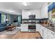 Cozy kitchen featuring white cabinets, stainless steel appliances, and a view of the living area at 536 Brookhaven Rd, Statesville, NC 28625