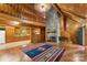 Cozy living room featuring wood paneling, a stone fireplace, and open access to the kitchen area at 536 Brookhaven Rd, Statesville, NC 28625