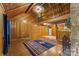 Open living room with wood-paneled walls, vaulted ceilings, stone fireplace, and adjacent kitchen area at 536 Brookhaven Rd, Statesville, NC 28625