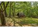 A charming outbuilding provides extra storage or a cozy retreat nestled among mature trees on the property at 536 Brookhaven Rd, Statesville, NC 28625