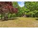 Scenic view of a charming cabin nestled on a hill among mature trees on a well maintained yard at 536 Brookhaven Rd, Statesville, NC 28625