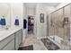 Modern bathroom with a glass-enclosed shower, tile floors, gray vanity, and access to the closet at 5727 Lavaux Ct, Charlotte, NC 28214
