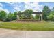 Stone community entrance with an arbor, mature trees and immaculate landscaping at 5727 Lavaux Ct, Charlotte, NC 28214