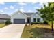 Charming single-story home with a well-manicured lawn, a gray garage door, and light blue siding at 5727 Lavaux Ct, Charlotte, NC 28214