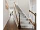 Hallway view featuring a carpeted staircase with wood railings and dark wood floors leading into the house at 5727 Lavaux Ct, Charlotte, NC 28214
