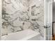 Updated bathroom with tiled walls and a white alcove tub and chrome fixtures at 6040 Morris Farm Ln, Mint Hill, NC 28227