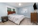Bedroom features carpet, a window for natural light and is staged with a bed and side tables at 6040 Morris Farm Ln, Mint Hill, NC 28227