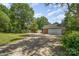 This driveway and attached garage are surrounded by mature trees, providing ample parking space at 6040 Morris Farm Ln, Mint Hill, NC 28227