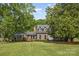 Beautiful brick home with a well-manicured lawn and mature trees, offering a picturesque curb appeal at 6040 Morris Farm Ln, Mint Hill, NC 28227