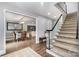 Inviting hallway with hardwood floors, a staircase, and a view of the dining room at 6040 Morris Farm Ln, Mint Hill, NC 28227